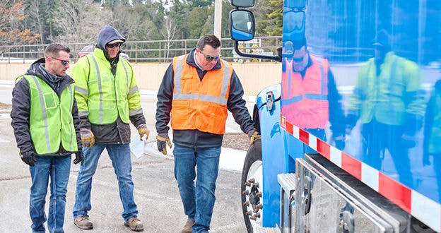 Manager instructing drivers near truck