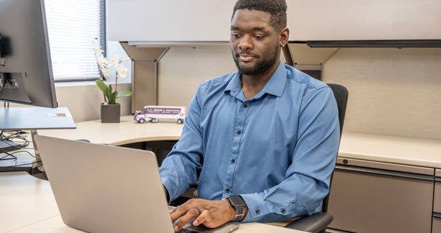 manager at desk working on a laptop