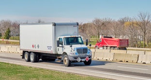 Box truck and dump truck on divided highway