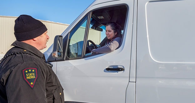 Inspector talking to driver inside transport vehicle