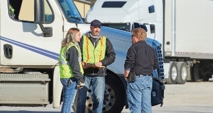 Three people meeting by semi truck