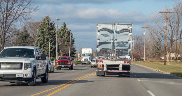 Semi with trailer and pickup truck on residential road